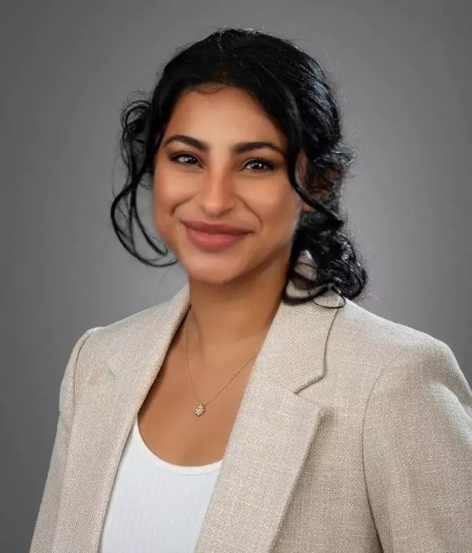 A woman wearing a brown jacket with a smile on her face, Salena Chowdhury for Mason LLP