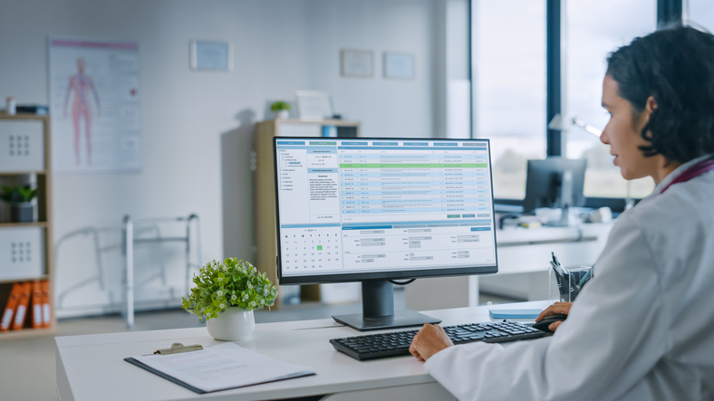 doctor looking at files on a computer - doctors imaging group data breach
